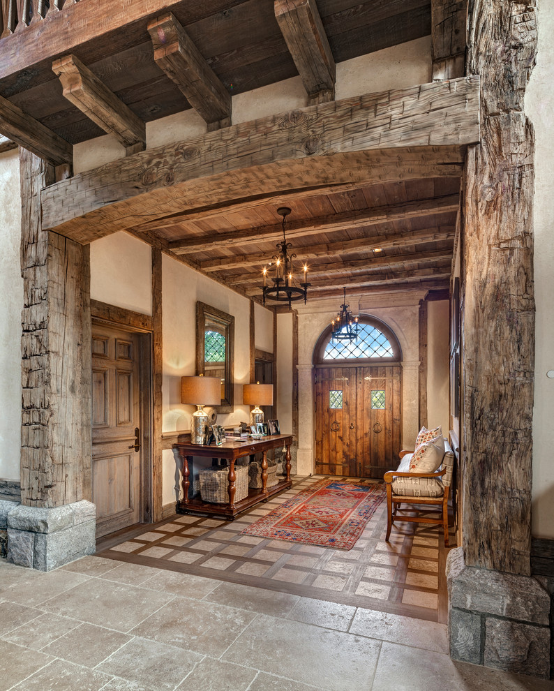 Immagine di un ingresso tradizionale con una porta a due ante, una porta in legno bruno, pareti beige e pavimento in pietra calcarea