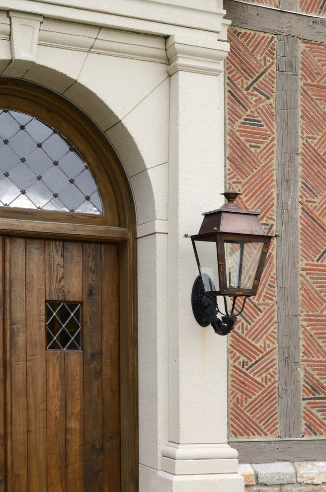 На фото: входная дверь в классическом стиле с красными стенами, двустворчатой входной дверью и входной дверью из дерева среднего тона с