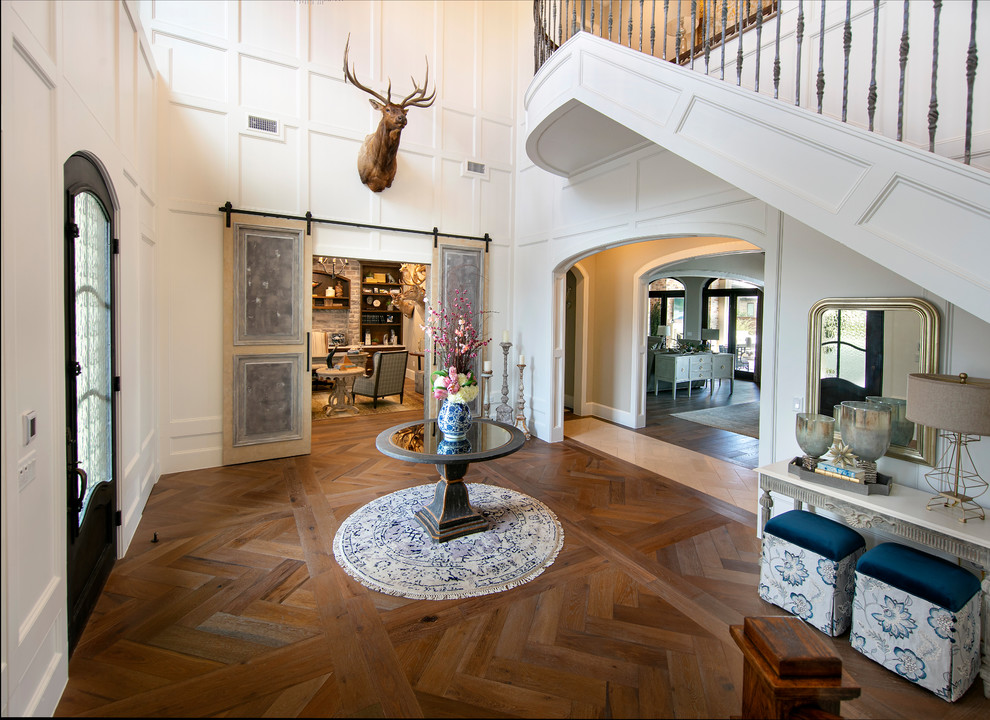 Large elegant dark wood floor entryway photo in Dallas with white walls and a metal front door