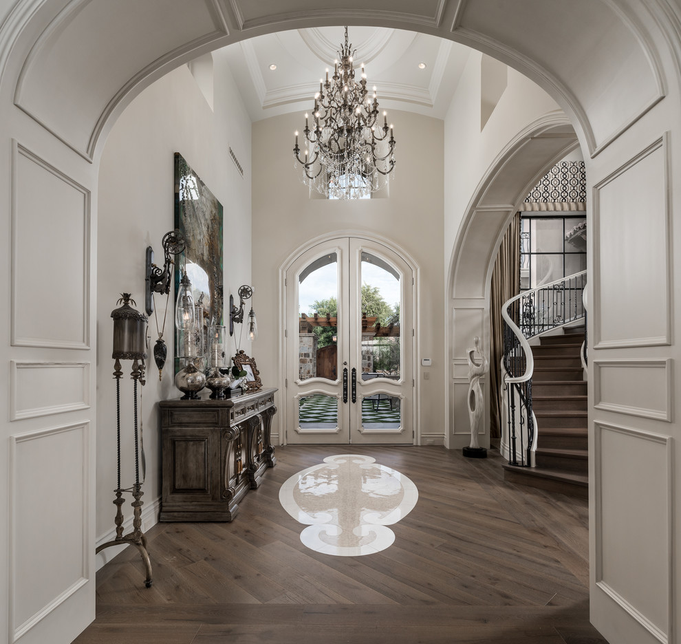 フェニックスにある高級な巨大なシャビーシック調のおしゃれな玄関ロビー (白い壁、濃色無垢フローリング、白いドア、茶色い床) の写真