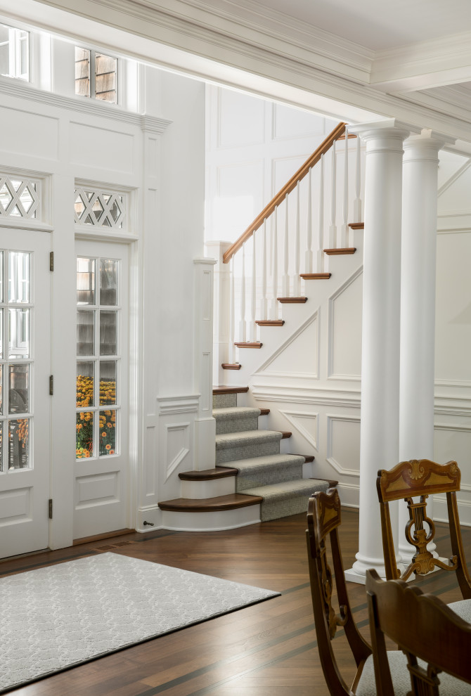 Esempio di un ampio ingresso con pareti bianche, pavimento in legno massello medio, una porta a due ante, una porta bianca, pavimento marrone, soffitto a cassettoni e pannellatura