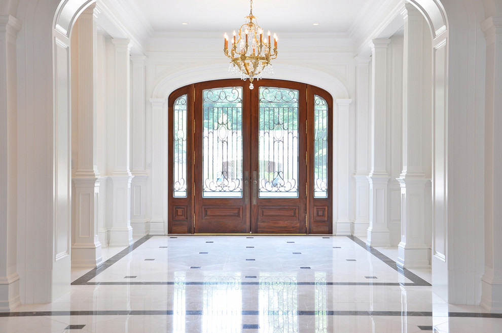 Foto di un grande ingresso chic con pareti beige, pavimento in marmo, una porta a due ante, una porta in legno bruno e pavimento bianco