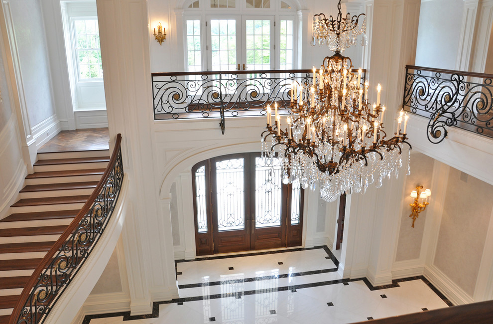 Großes Klassisches Foyer mit beiger Wandfarbe, Marmorboden, Doppeltür, hellbrauner Holzhaustür und weißem Boden in New York