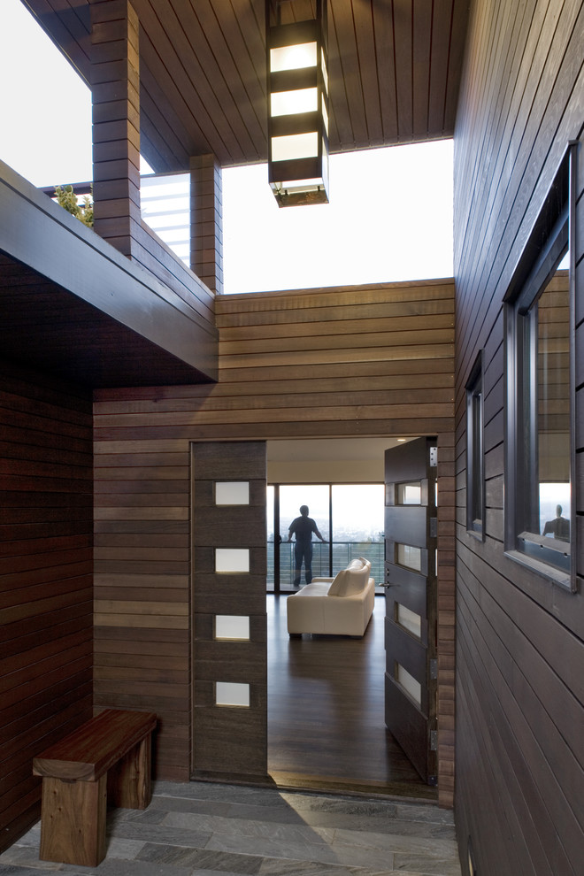 Idée de décoration pour une porte d'entrée minimaliste avec une porte simple et une porte en bois foncé.