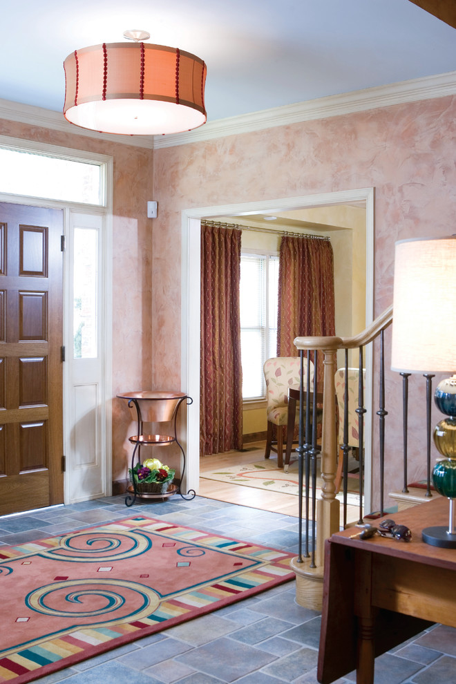 Стильный дизайн: входная дверь среднего размера в стиле фьюжн с розовыми стенами, полом из керамогранита, одностворчатой входной дверью, входной дверью из дерева среднего тона и серым полом - последний тренд