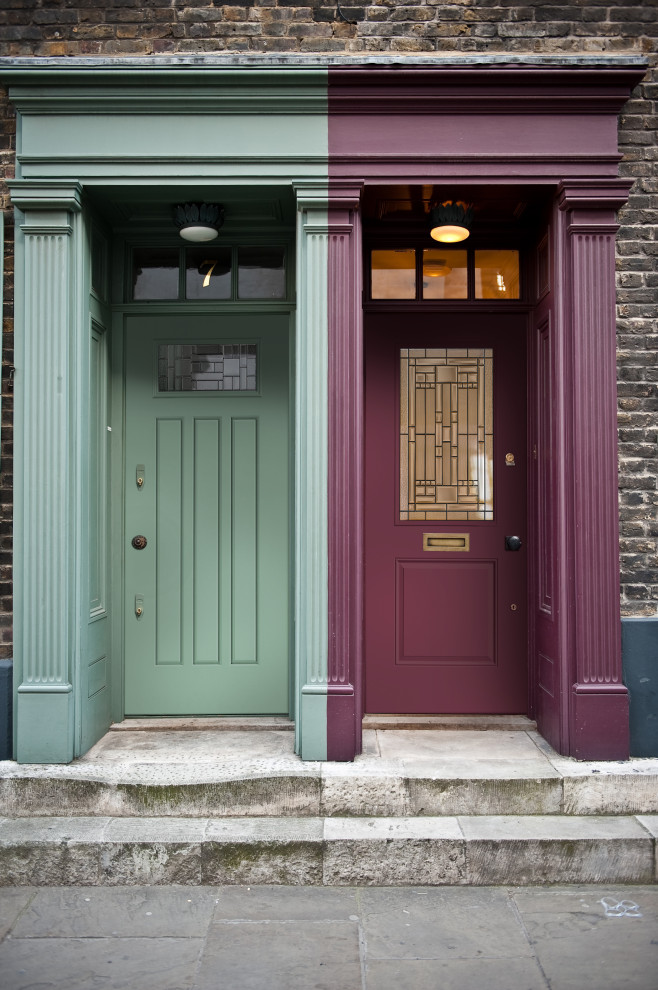 Aménagement d'une grande porte d'entrée classique avec un mur multicolore, sol en béton ciré, une porte simple et un sol gris.
