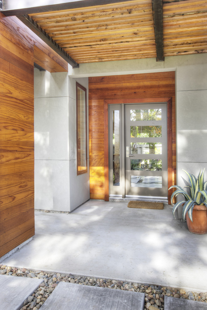 Foto de puerta principal actual de tamaño medio con puerta gris, paredes grises, suelo de cemento, puerta simple y suelo gris