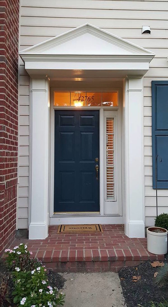 Diseño de puerta principal clásica de tamaño medio con paredes beige, suelo de ladrillo, puerta simple y puerta de madera oscura