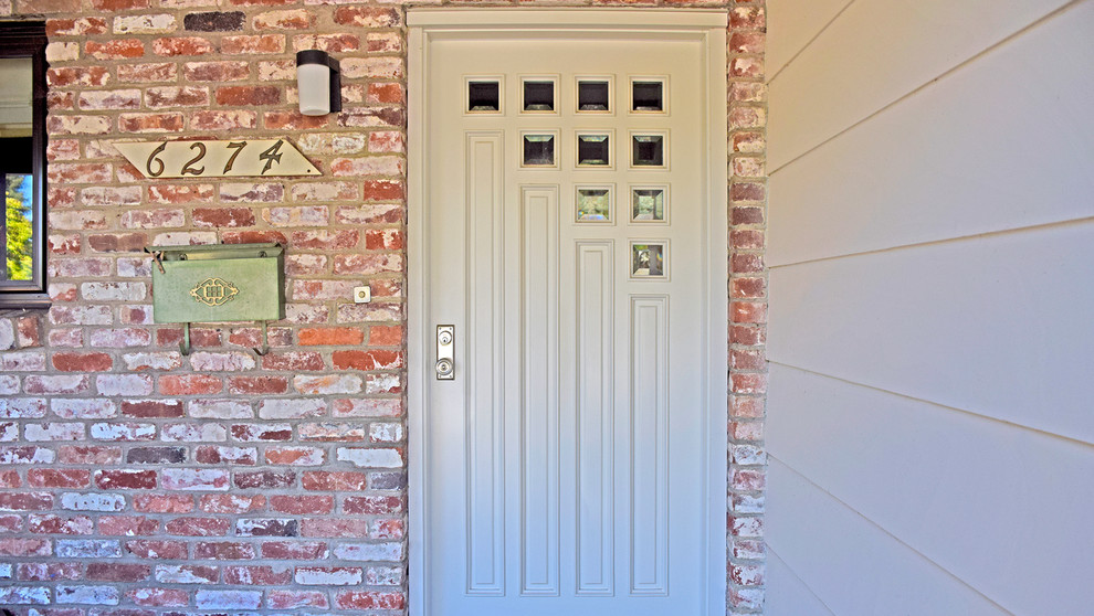 Aménagement d'une porte d'entrée classique avec une porte simple et une porte en bois foncé.