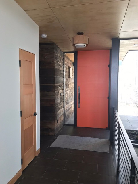 Imagen de puerta principal minimalista con puerta simple y puerta naranja