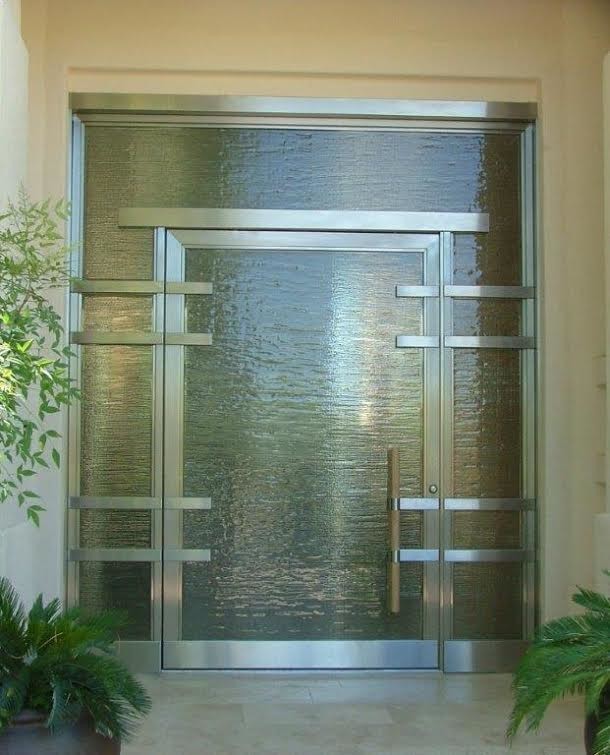 Стильный дизайн: большая входная дверь в стиле модернизм с одностворчатой входной дверью, стеклянной входной дверью, бежевыми стенами и полом из травертина - последний тренд