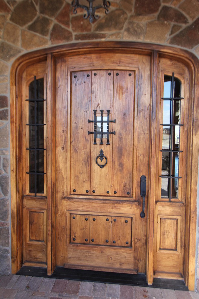 На фото: большая входная дверь в стиле рустика с одностворчатой входной дверью, входной дверью из дерева среднего тона и бежевыми стенами с