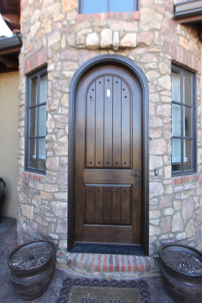 Exemple d'une porte d'entrée montagne de taille moyenne avec un mur beige, un sol en brique, une porte simple et une porte en bois foncé.