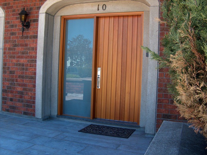 モントリオールにあるモダンスタイルのおしゃれな玄関ドア (木目調のドア) の写真