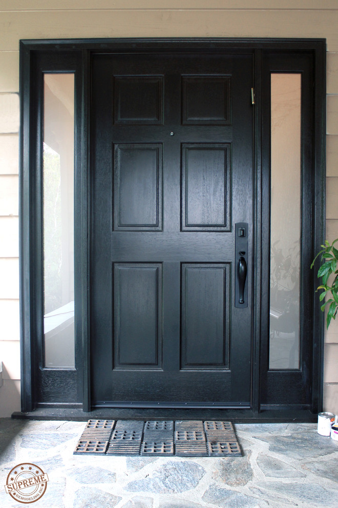 Cette image montre une porte d'entrée design de taille moyenne avec un mur marron, sol en béton ciré, une porte simple et une porte noire.