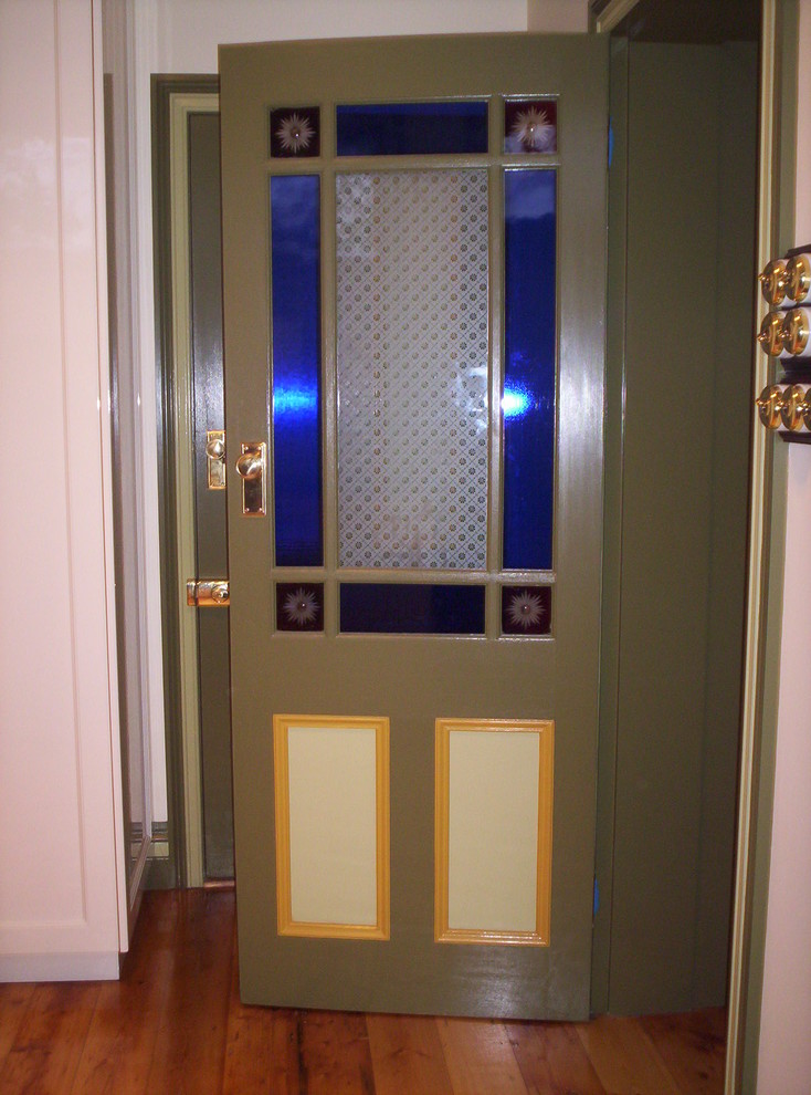 Immagine di una porta d'ingresso classica con pareti verdi, parquet scuro e una porta singola