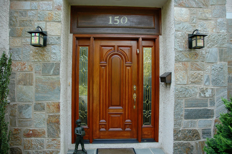 Immagine di una porta d'ingresso classica di medie dimensioni con una porta singola e una porta in legno bruno