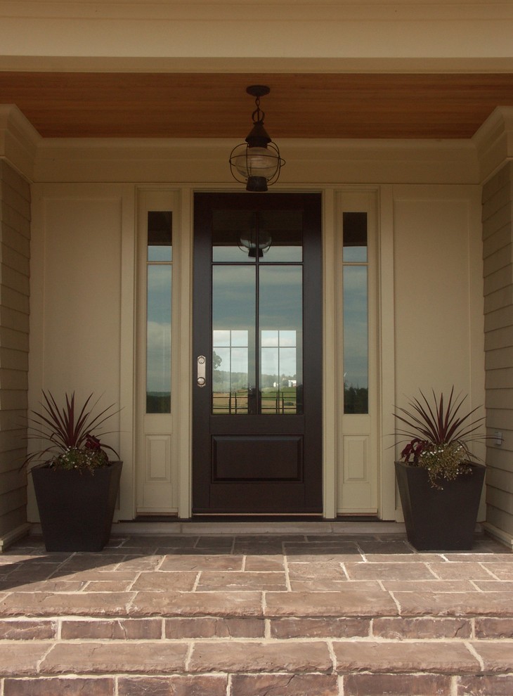 Пример оригинального дизайна: входная дверь среднего размера: освещение с бежевыми стенами, полом из сланца, одностворчатой входной дверью и входной дверью из темного дерева