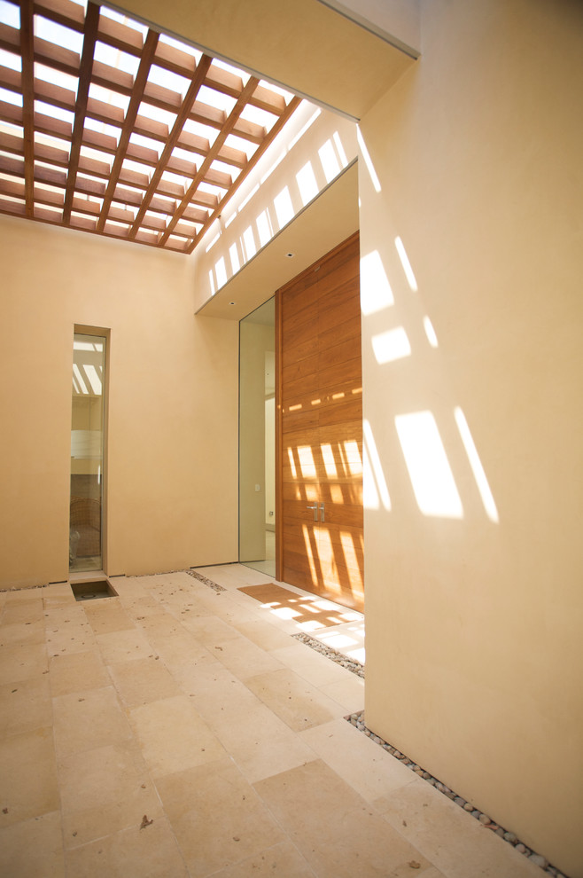 Idée de décoration pour une porte d'entrée design avec un sol en travertin, une porte double et une porte en bois brun.