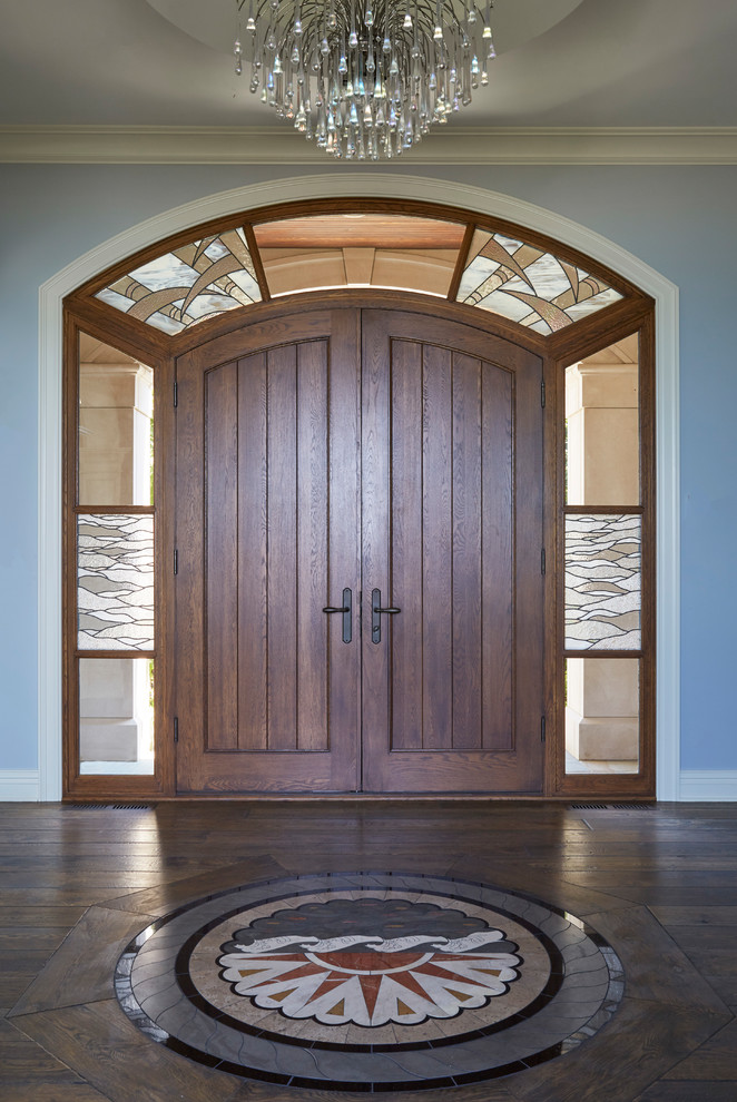 Example of a large tuscan dark wood floor and brown floor entryway design in Chicago with blue walls and a dark wood front door