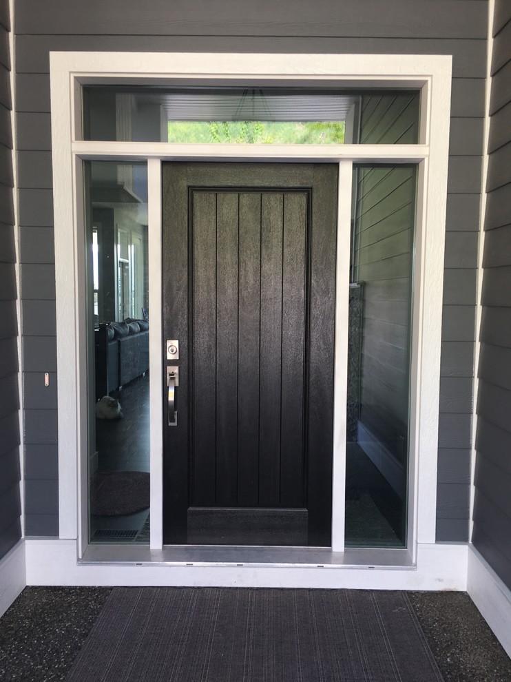 Foto di una porta d'ingresso stile americano con pareti grigie, pavimento in cemento, una porta singola, una porta nera e pavimento grigio