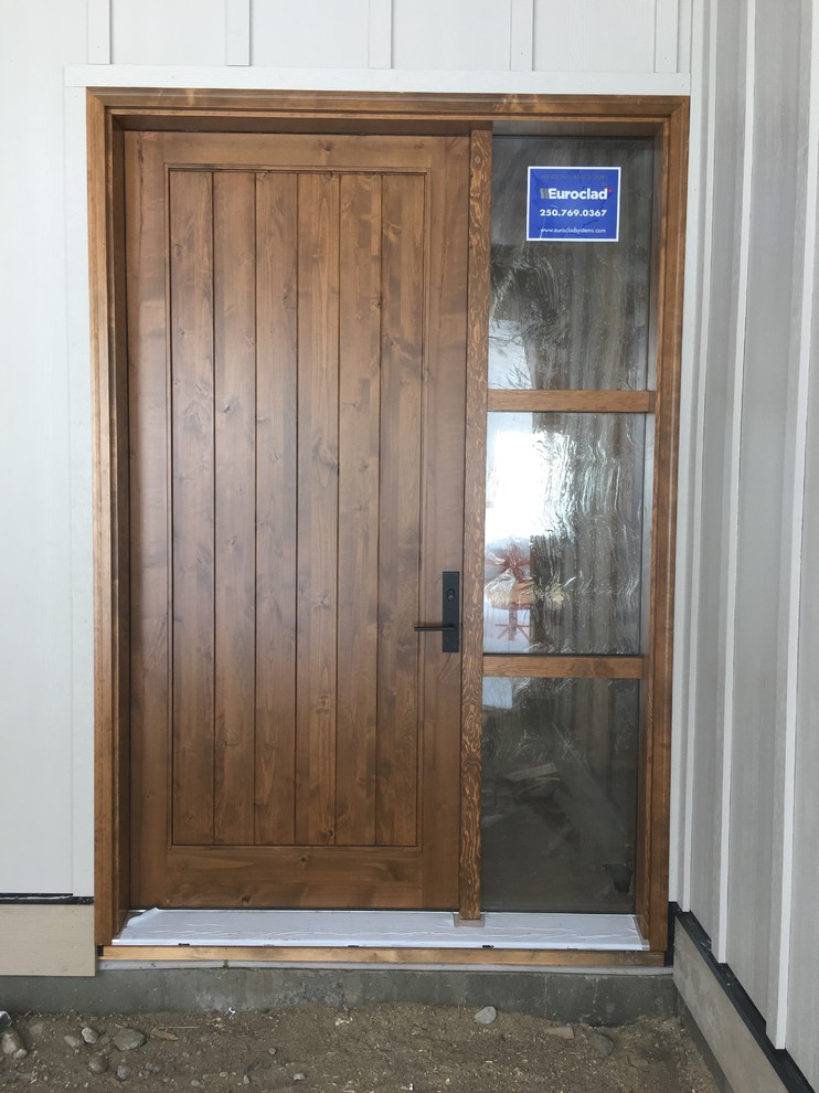 Cette image montre une porte d'entrée craftsman avec un mur blanc, une porte simple et une porte en bois brun.