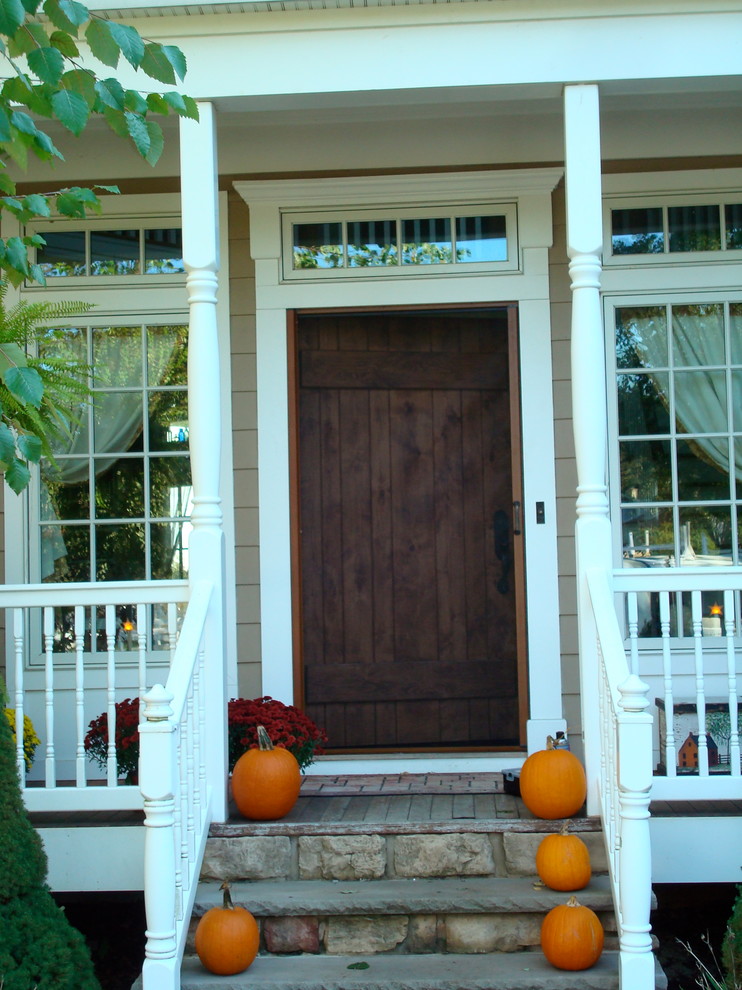 Стильный дизайн: входная дверь среднего размера в стиле кантри с входной дверью из дерева среднего тона, бежевыми стенами и одностворчатой входной дверью - последний тренд