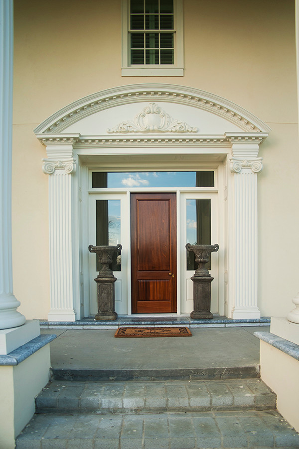 他の地域にあるトラディショナルスタイルのおしゃれな玄関 (ベージュの壁、濃色木目調のドア) の写真