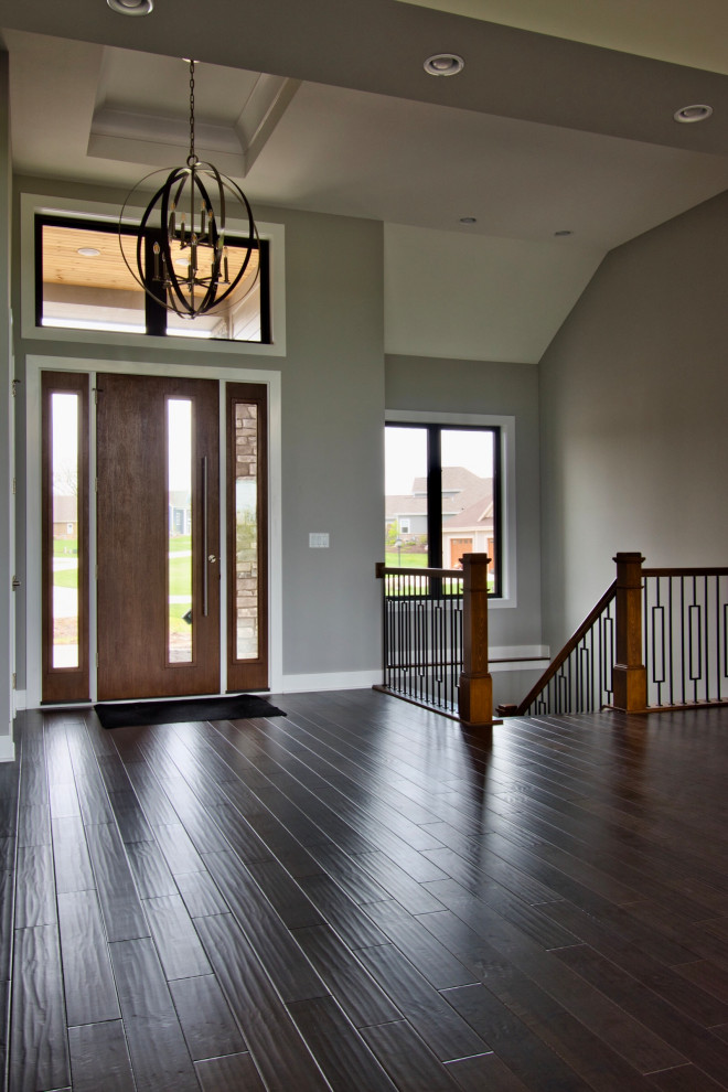 Großes Modernes Foyer mit grauer Wandfarbe, dunklem Holzboden, Einzeltür, dunkler Holzhaustür, braunem Boden und eingelassener Decke in Milwaukee