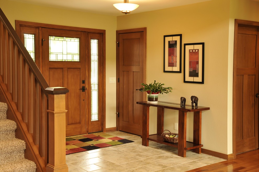 Idee per un ingresso con pareti gialle, pavimento in legno massello medio, una porta singola e una porta in legno bruno