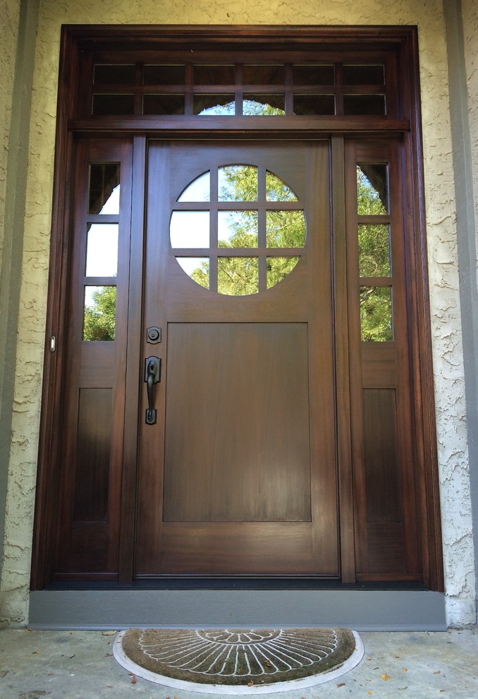 На фото: входная дверь среднего размера в стиле кантри с одностворчатой входной дверью, входной дверью из темного дерева и серыми стенами