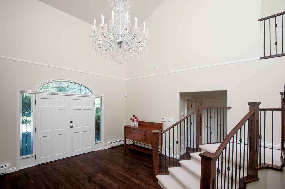 Inspiration pour un grand hall d'entrée craftsman avec un mur beige, parquet foncé, une porte double et une porte blanche.