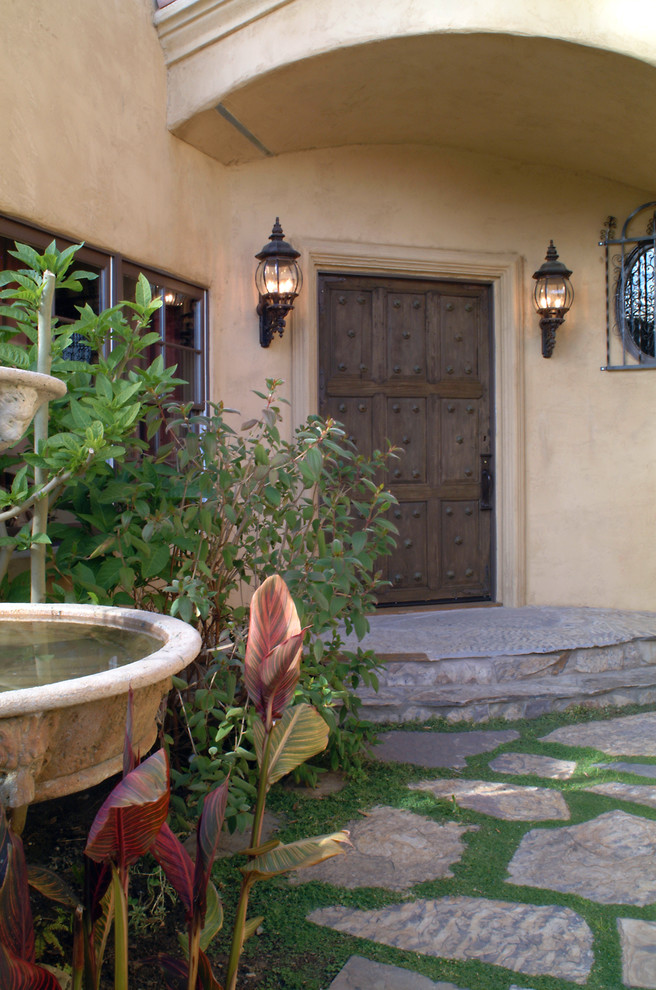 Example of a tuscan entryway design in Charlotte with a dark wood front door