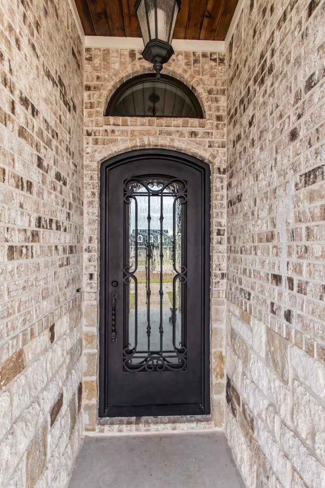 Foto di una piccola porta d'ingresso classica con pareti multicolore, pavimento in cemento, una porta singola, pavimento grigio, soffitto in legno e pareti in mattoni