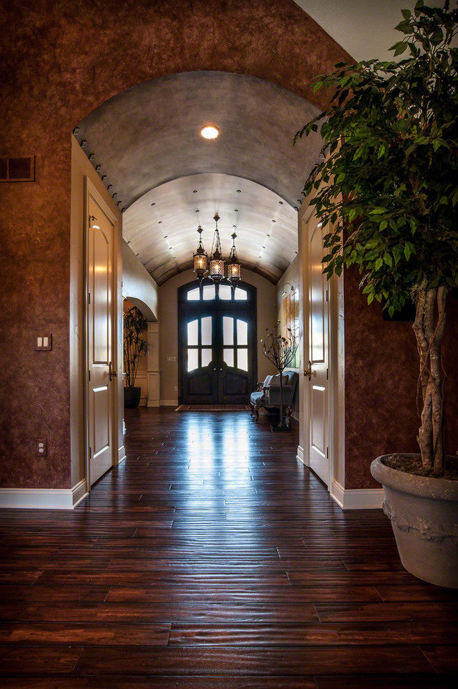 Esempio di un grande corridoio boho chic con pareti con effetto metallico, parquet scuro, una porta a due ante e una porta in legno scuro
