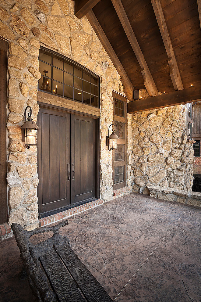 Ejemplo de puerta principal rural grande con paredes marrones, suelo de baldosas de terracota, puerta doble y puerta de madera oscura