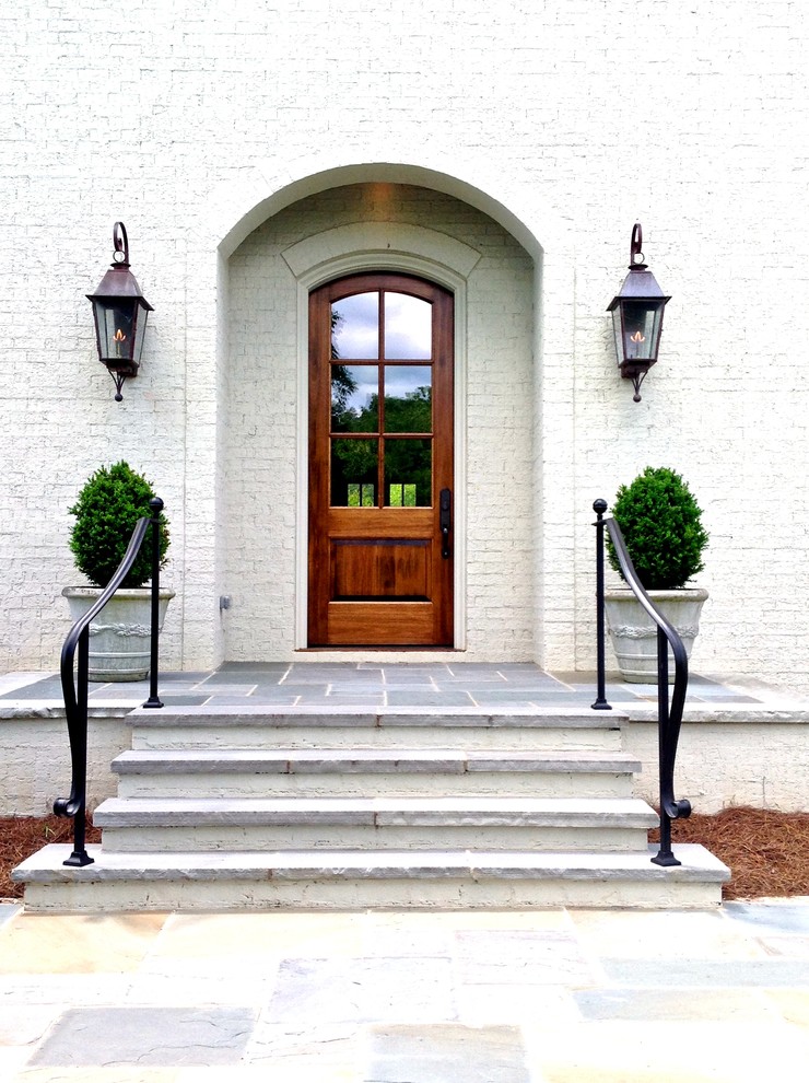 Idee per una porta d'ingresso chic di medie dimensioni con una porta singola, una porta in legno bruno, pareti bianche, pavimento in ardesia e pavimento grigio