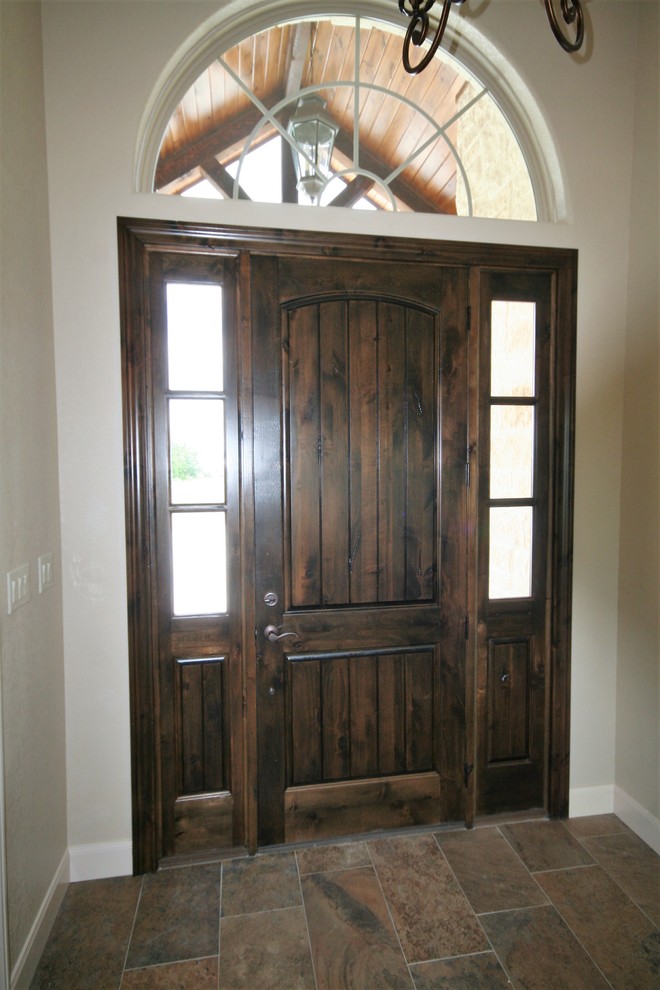 Cette image montre une porte d'entrée traditionnelle de taille moyenne avec un mur beige, un sol en carrelage de porcelaine, une porte simple, une porte en bois foncé et un sol multicolore.