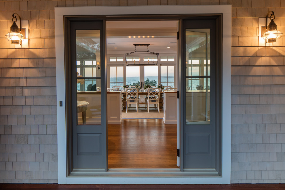 Esempio di un ingresso o corridoio stile marino di medie dimensioni con pavimento in legno massello medio, una porta singola, una porta grigia e pavimento marrone