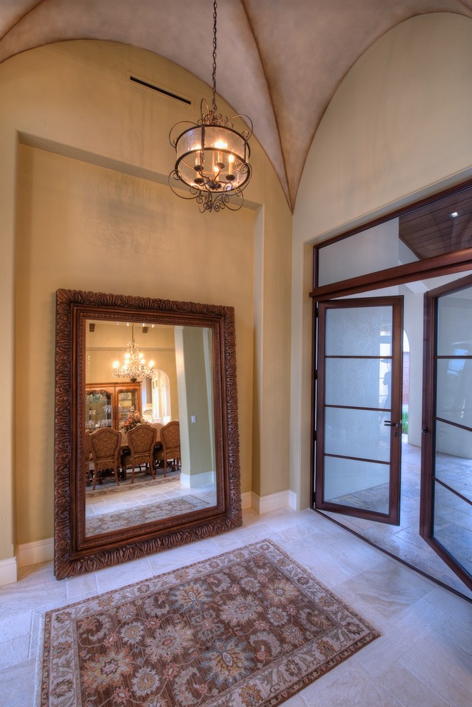 Cette image montre un hall d'entrée traditionnel avec un mur beige, une porte double et une porte en verre.