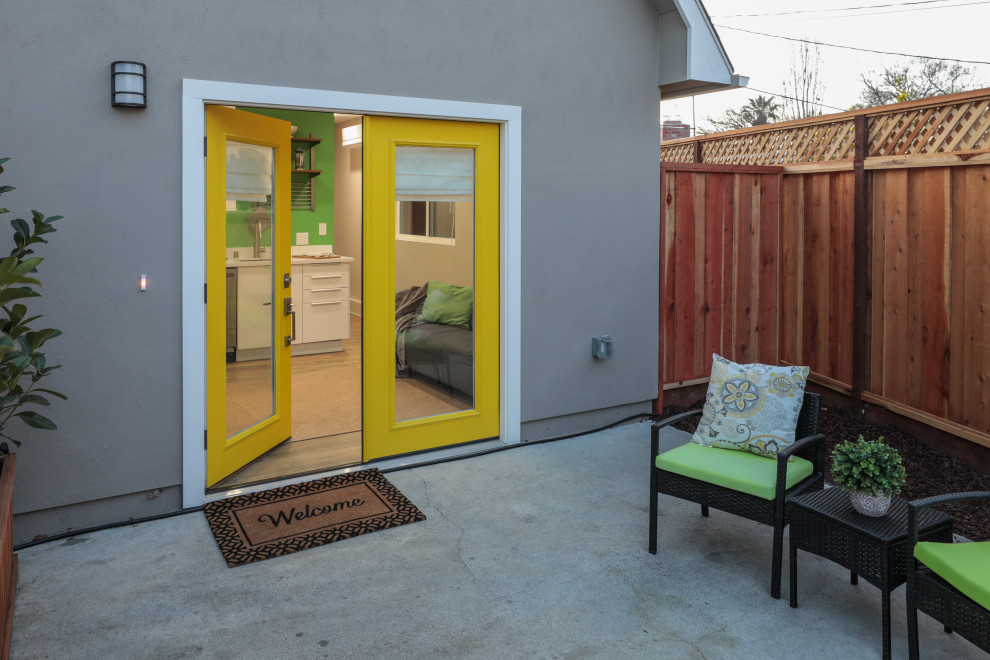 Свежая идея для дизайна: входная дверь в скандинавском стиле с серыми стенами, полом из ламината, двустворчатой входной дверью, желтой входной дверью и коричневым полом - отличное фото интерьера