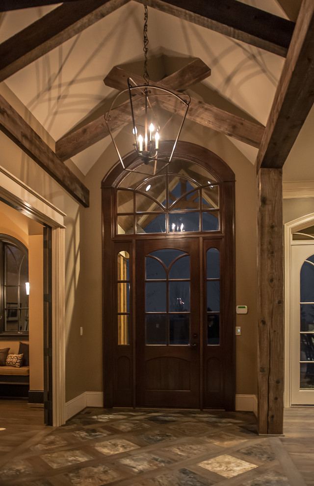 Inspiration for a large rustic foyer in Louisville with brown walls, slate flooring and a dark wood front door.