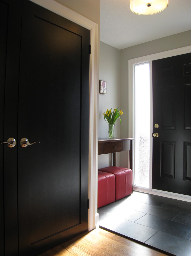 Entryway - traditional black floor entryway idea in Montreal with a black front door