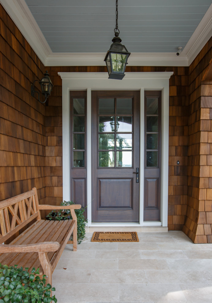 Immagine di una grande porta d'ingresso chic con pavimento in pietra calcarea, una porta singola, una porta in legno bruno e soffitto in perlinato