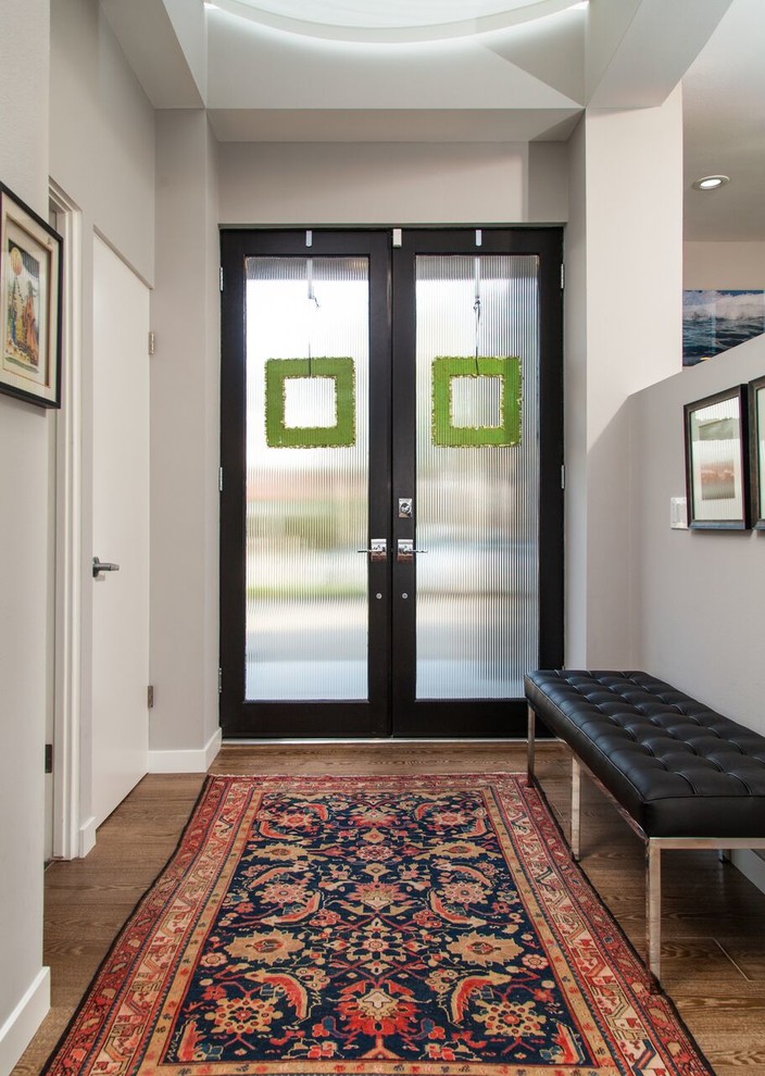 Kleiner Mid-Century Eingang mit Doppeltür, Haustür aus Glas, grauer Wandfarbe und braunem Holzboden in Los Angeles