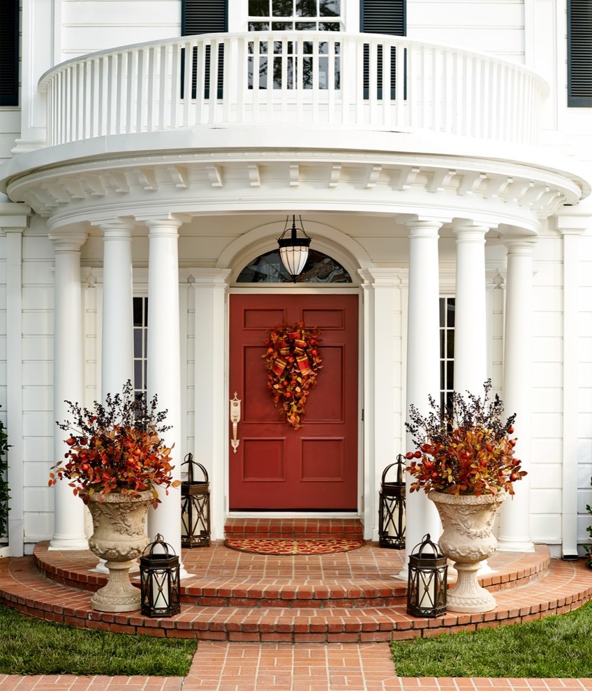 This is an example of a classic front door in Other with white walls, a single front door and a red front door.
