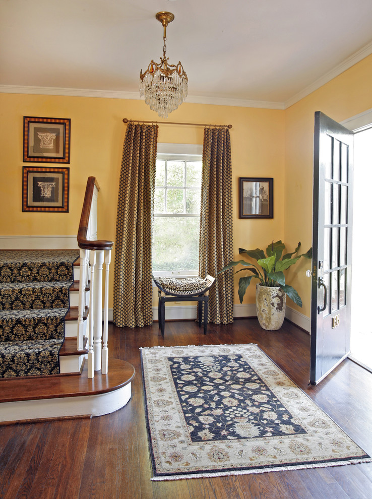 Entryway - mid-sized traditional medium tone wood floor entryway idea in Dallas with orange walls and a black front door