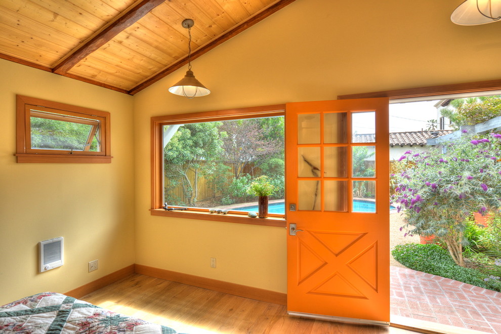 Immagine di una piccola porta d'ingresso stile marinaro con pareti gialle, parquet chiaro, una porta singola e una porta arancione