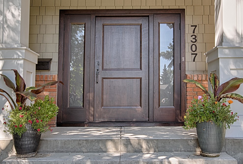 Пример оригинального дизайна: входная дверь в стиле кантри с бежевыми стенами, бетонным полом, одностворчатой входной дверью и входной дверью из темного дерева