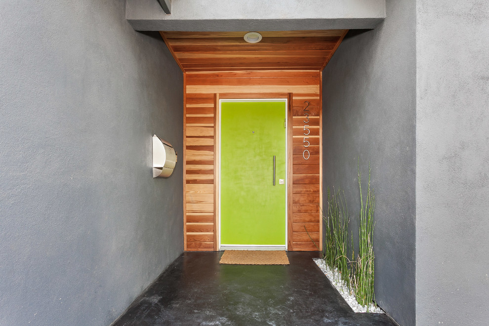 Idee per una porta d'ingresso minimalista di medie dimensioni con pavimento in cemento, una porta singola, una porta verde, pareti marroni e pavimento nero